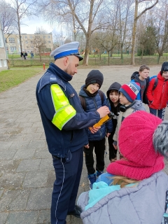policjant Komendy Miejskiej Policji w Olsztynie z grupą uczniów sp3 w Olsztynie podczas prezentacji badania alkomatem