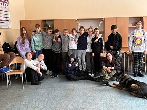 Zdjęcie przedstawia grupę uczniów z psem.
